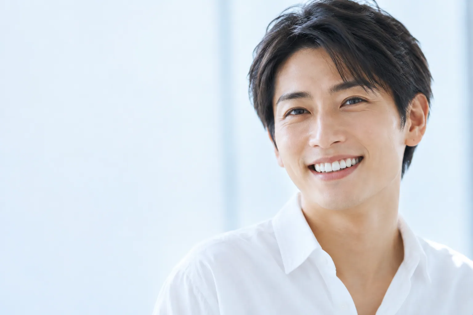 明るい自然光の中で笑う男性